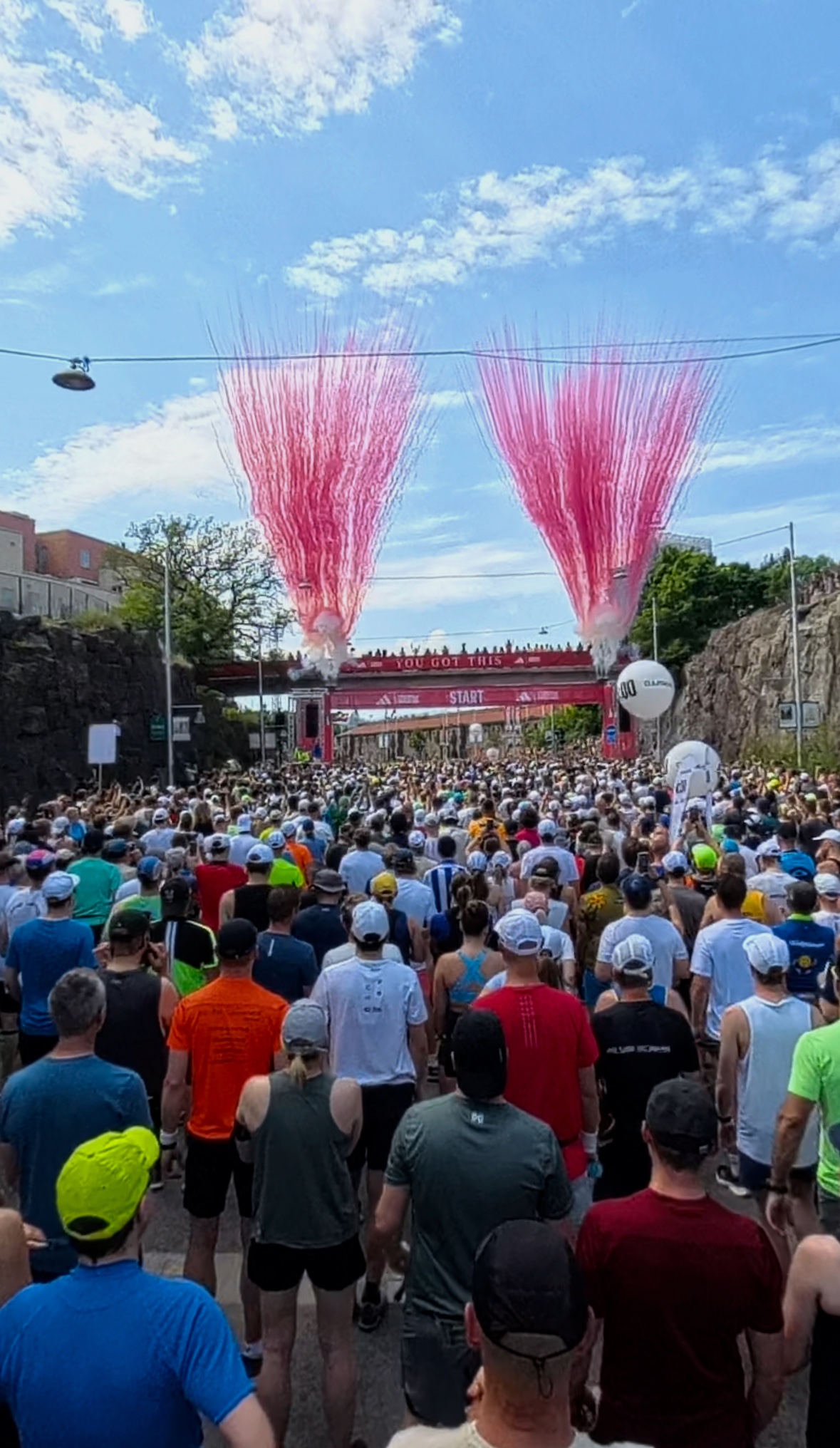 Pack of runners gathered at a start line in early morning light